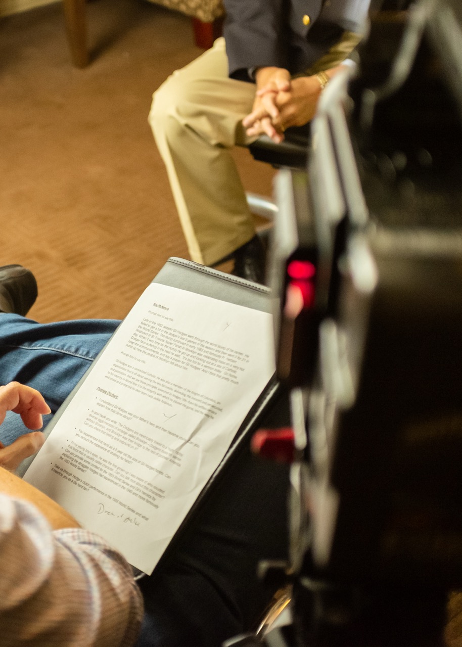 A filmmaker reviews a printed script on-set, showing how to script a commercial video with real production context and direction.