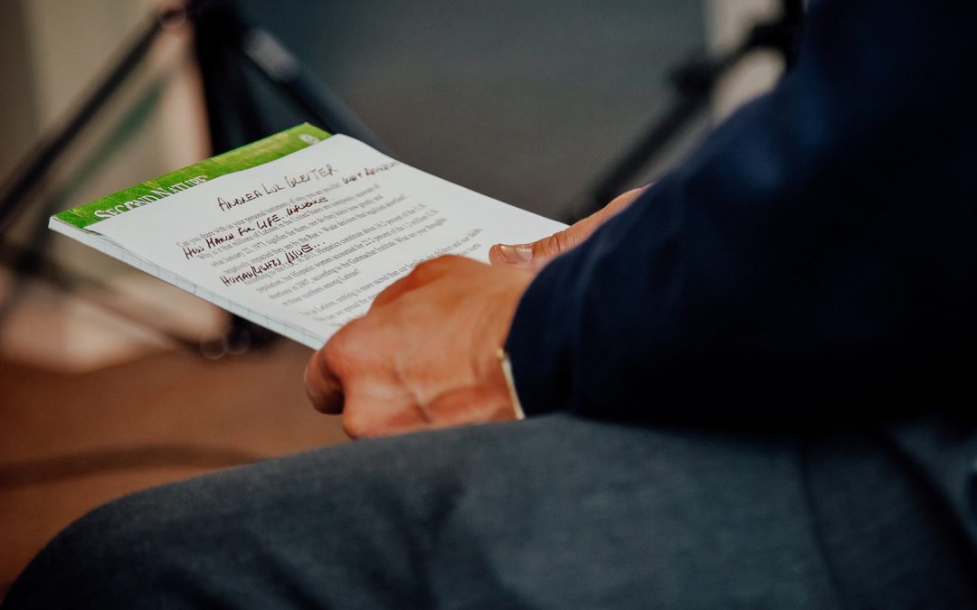 A person reviews a printed script with handwritten notes during a planning session, illustrating the early drafting process in how to script a commercial video.