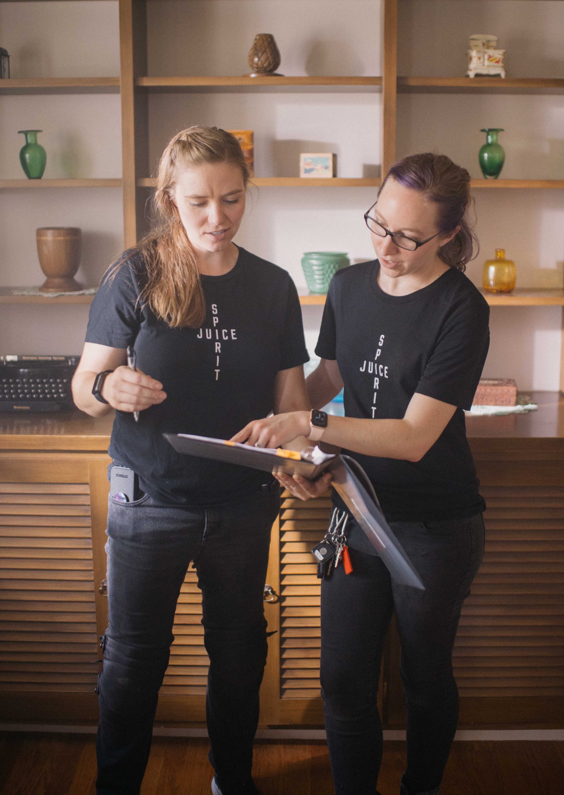Two Catholic video production team members review notes during a planning session, highlighting script and storyboard best practices for thoughtful, mission-driven video production.